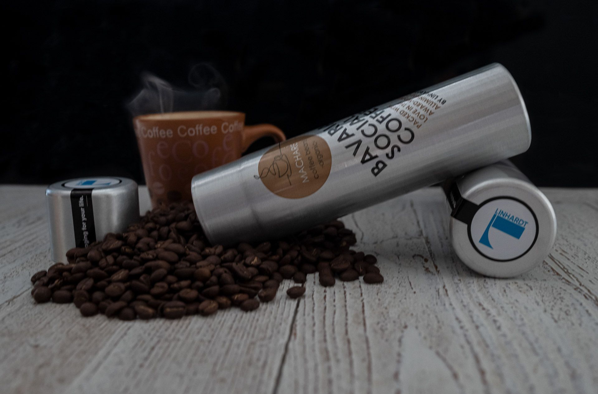 Kaffeedose mit Kaffee am Tisch und dampfender Tasse